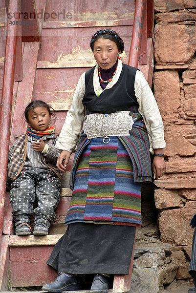 Tibetische Pilgerin in Tracht mit Kind vor Holztreppe Kloster Rongbuk Tibet China