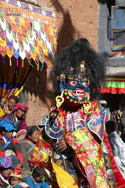 Mönch trägt schreckliche blaue Maske eines Dämon bei Festival in bunt geschmücktem Kloster Rongbuk Tibet China