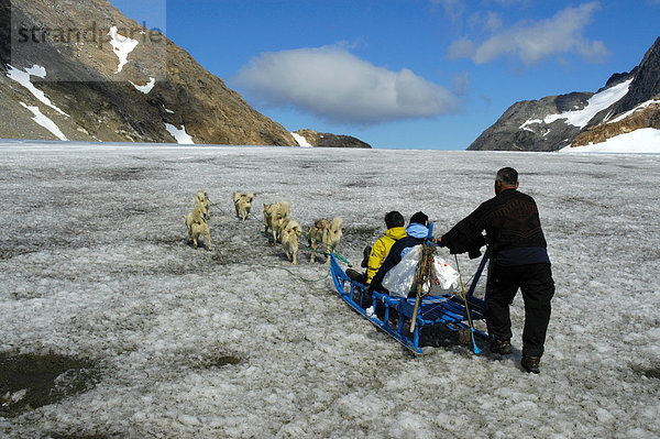 Hundeschlitten mit Schlittenhunden Gästen und Inuit Grönländer auf dem Apusiak Gletscher Ostgrönland
