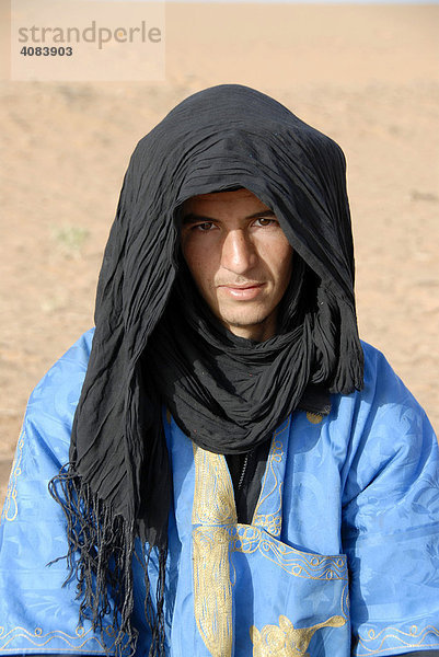 Portrait Tuareg trägt blaues Gewand mit schwarzem Turban in Erg Chebbi Merzouga Marokko