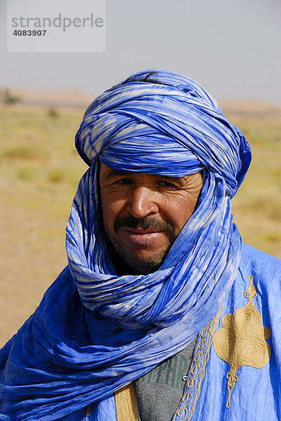 Portrait Tuareg trägt blaues Gewand mit Turban in Erg Chebbi Merzouga Marokko