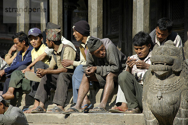 Männer sitzen nebeneinander Patan Kathmandu Nepal