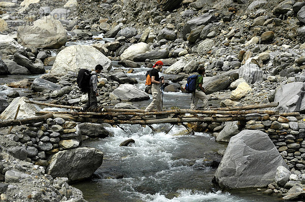 Menschen überqueren eine einfache Brücke über einen Gebirgsbach Annapurna Region Nepal