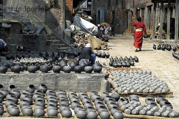 Töpfer mit vielen Gefäßen zum Trocknen auf den Töpferplatz Potters' Square Bhaktapur Nepal