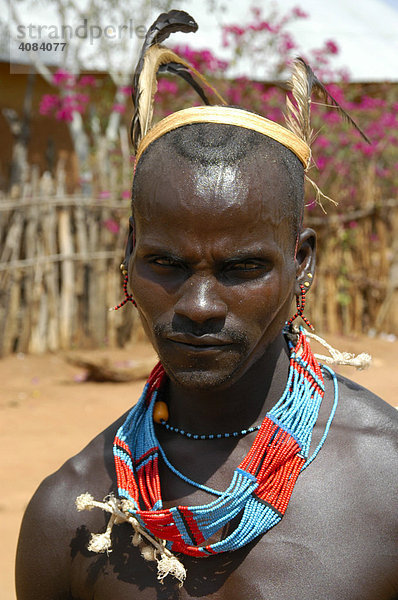 Mann mit bunter Halskette und Federschmuck auf seinem Kopf vom Volk der Hamar Markt von Dimeka Äthiopien