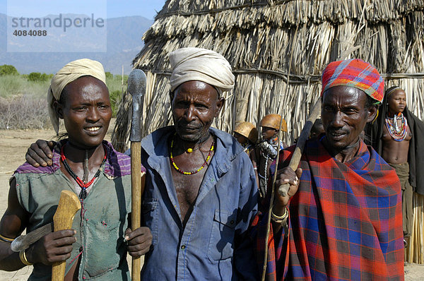 Drei Männer vom Volk der Arbore mit verschiedenen Kopfbedeckungen vor Strohhütte bei Weyto Äthiopien