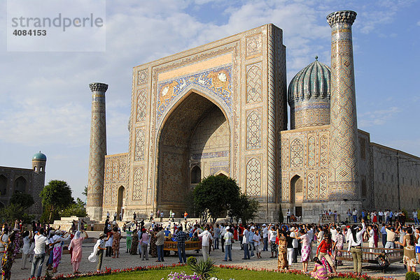 Menschen tanzen vor Medrese Sher-Dor Registan Samarkand Usbekistan