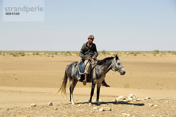 Nomaden junger Reiter auf Pferd in der Sandwüste Kysylkum Usbekistan