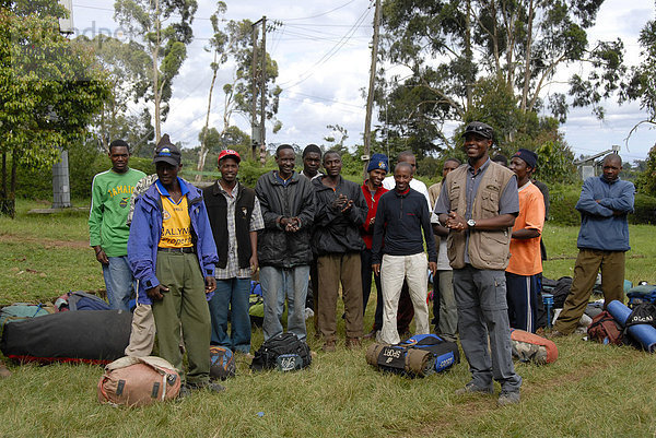 Einheimischer Bergführer mit versammelter Mannschaft an Trägern am Marangu Gate Kilimandscharo Tansania