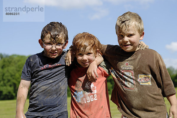 Drei wilde Freunde Jungen total Schlamm verdreckt