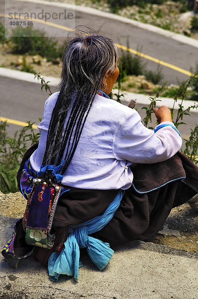 Pilgerin mit traditioneller Haartracht am Kloster Ganden (4300m) bei Lhasa  Tibet