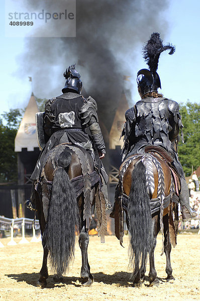 Zwei schwarze Ritter von hinten sitzen auf ihren Pferden  im Hintergrund schwarze Rauchwolken  Kaltenberger Ritterspiele  Kaltenberg  Oberbayern  Bayern  Deutschland