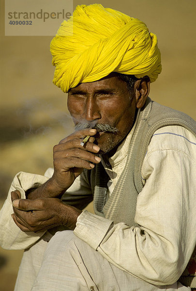 Mann mit gelbem Turban raucht eine Bidi Zigarette  Pushkar  Rajasthan  Indien
