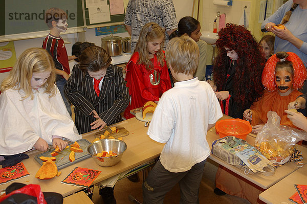 Kinder bereiten in Verkleidung Halloweenfeier vor