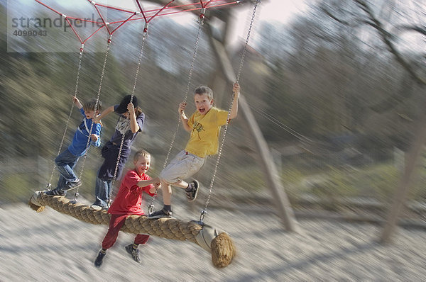 Vier Kinder auf einer großen Schaukel