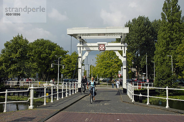 Fahrradfahrer auf Brücke mit dem Stadtwappen  Leiden  Südholland  Holland  Niederlande
