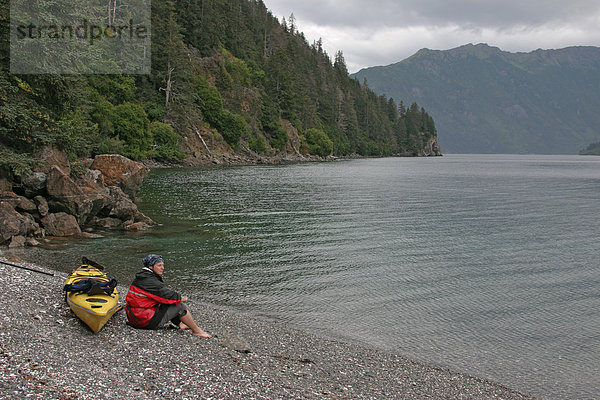 Einsamer Strand in der Otter Bay und Frau mit See Kayak ruht sich aus Alaska USA