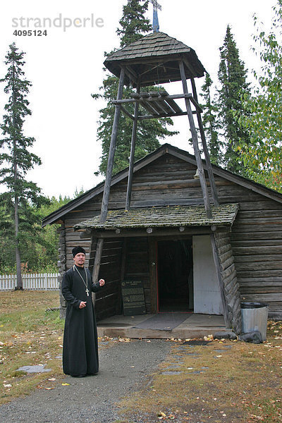 Ein russsisch orthodoxer Priester erklärt die Geschichte der St.Nicholas Kirche im Ort Eklutna Alaska USA