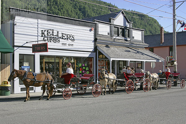 Pferdekutschen und historische Holzhäuser im Zentrum der Goldgräberstadt Skagway Alaska USA