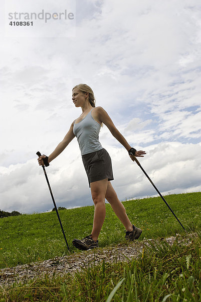 Junge Frau beim Nordic Walking