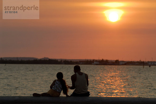 Mann mit Kind bei Sonnenuntergang am Malecon von Cienfuegos  Kuba