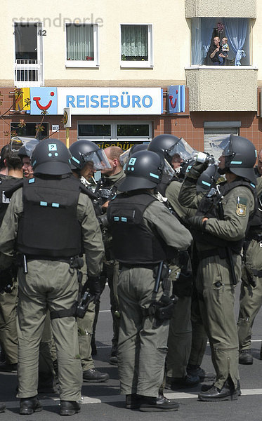Polizeistaffel der Einsatzbereitschaft im Einsatz vor einem Reisebüro unter der Beobachtung von Anwohnern