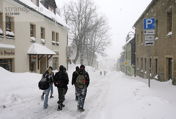 Jugendliche auf der schneebedeckten Hauptstraße in Oberwiesenthal  Erzgebirge  Sachsen  Deutschland