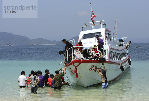 Asiatische Touristen entern ihren Ausflugsdampfer an der Küste der Insel Koh Kradan - Andaman See  Thailand  Asien