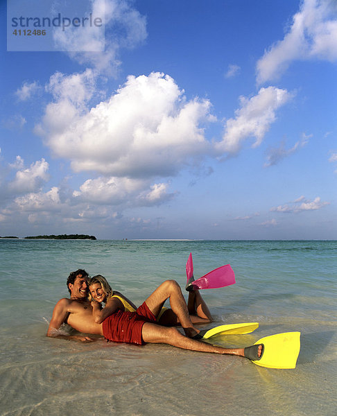 Junges Paar mit Schnorchelausrüstung im seichten Wasser  Strand  Malediven