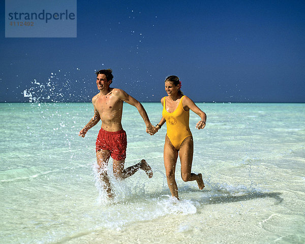 Junges Paar im seichten Wasser  Jogging  Malediven