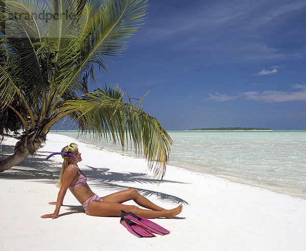 Junge Frau am Strand mit Schnorchelausrüstung neben einer Palme  Erholung  Strand  Meer  Malediven