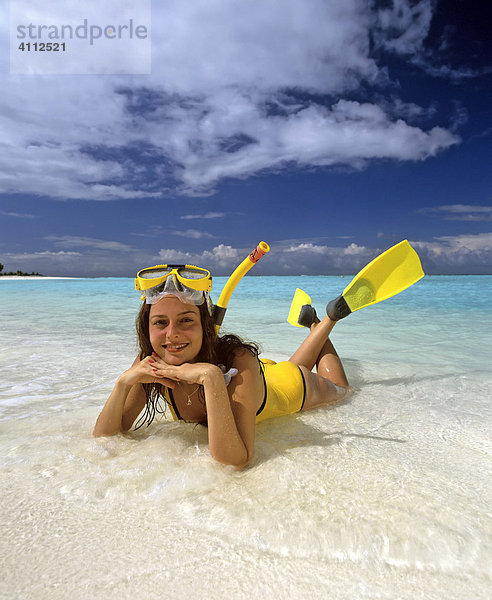 Junge Frau liegt im seichten Wasser  Strand  Schnorchelausrüstung  Meer  Malediven