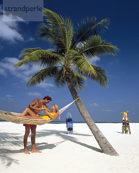 Palme  Junges Paar mit Drinks  Hängematte  Strand  Meer  Malediven