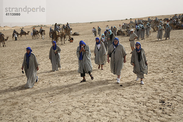 Touristen in arabischer Kleidung am Rande der Sahara in der Nähe von Douz  Tunesien