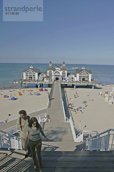 BRD Deutschland Insel Rügen Ostseebad Binz Blick auf die Seebrücke mit Restaurant der Strand mit Strandkörben Badegäste Freizeitaktivitäten Sonnenbaden Schiff beim Anlegen Treppe zur Brücke