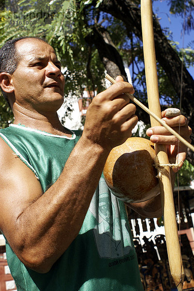 Mann mit dem afro-brasilianischen Musikinstrument Birimbao