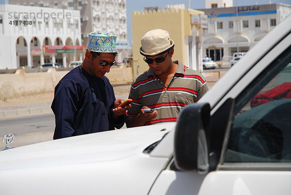 Junge Männer mit Mobiltelefon  Sur  Oman