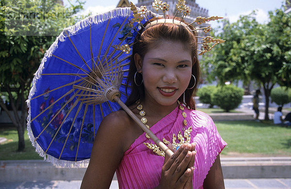 Junge Thailänderin in traditionellem Kostüm vor dem Arun-Kloster (Wat Arun)  Bangkok  Thailand  Südostasien