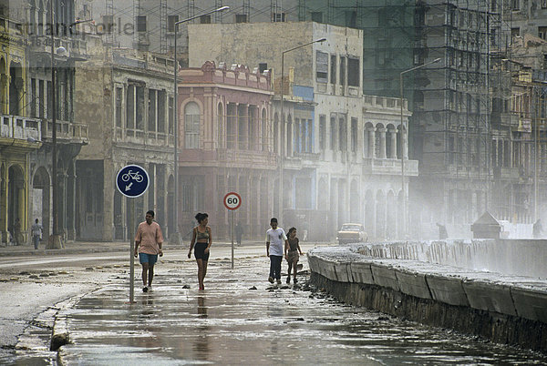 Spaziergänger im Sturm am Malecon  Havanna  Kuba