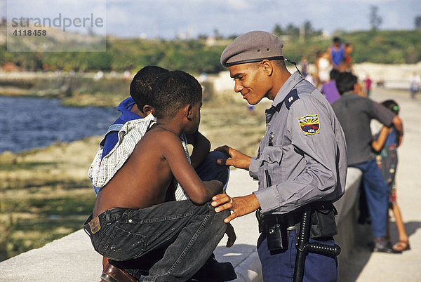 Polizist im Gespräch mit Kindern am Malecon  Havanna  Kuba