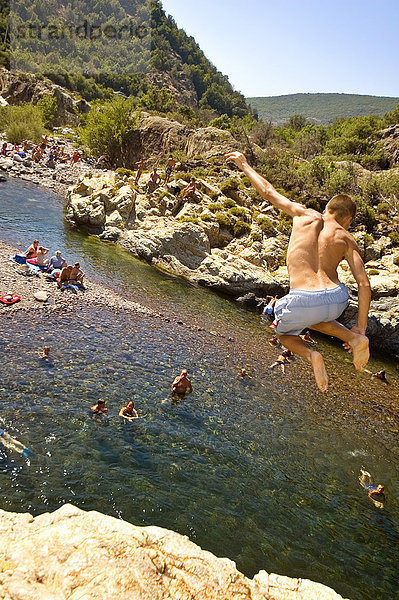 Junge springt von einem Felsen ins Wasser  Fango  Korsika  Frankreich