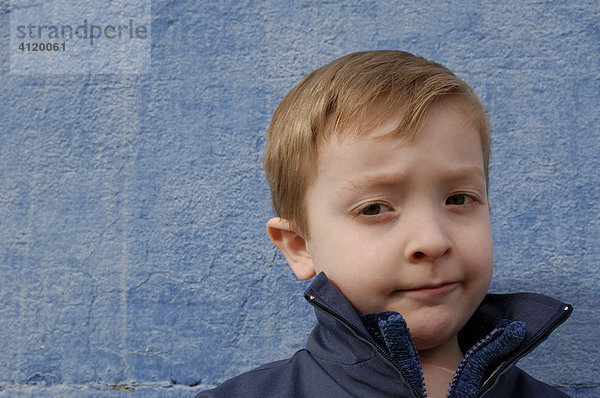 Junge (5 Jahre) vor blauer Wand