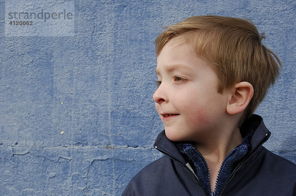 Junge (5 Jahre) vor blauer Wand
