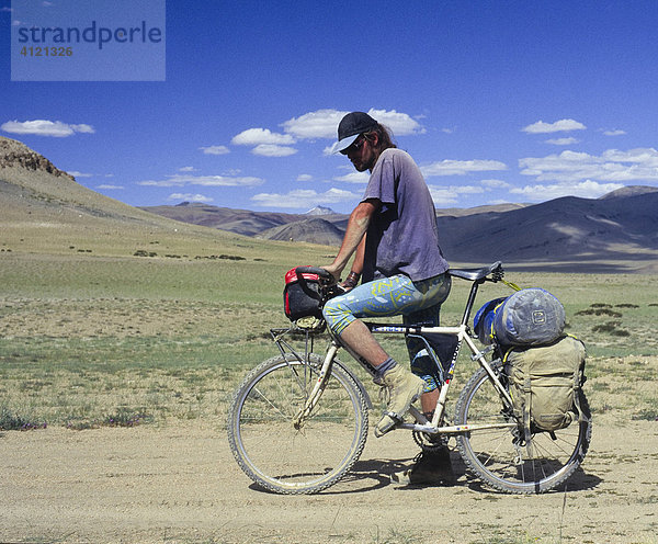 Reiseradfahrer auf vollbepacktem Mountainbike auf einer Sandpiste  Ladakh  indischer Himalaya  Ladakh  Indien