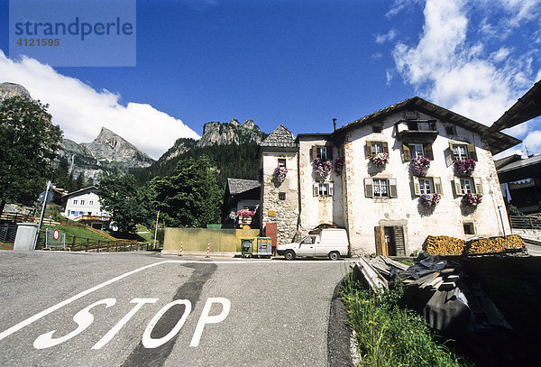 Straße mit Stop Markierung  Straßenmarkierung vor altem Bauernhaus mit Blumenschmuck in Viech  Vigo di Fassa  Trento  Italien  Europa