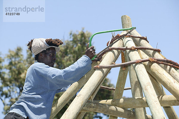 Mann baut Dachstuhl einer traditionellen Rundhütte  Rasta Community  Kapstadt  Südafrika