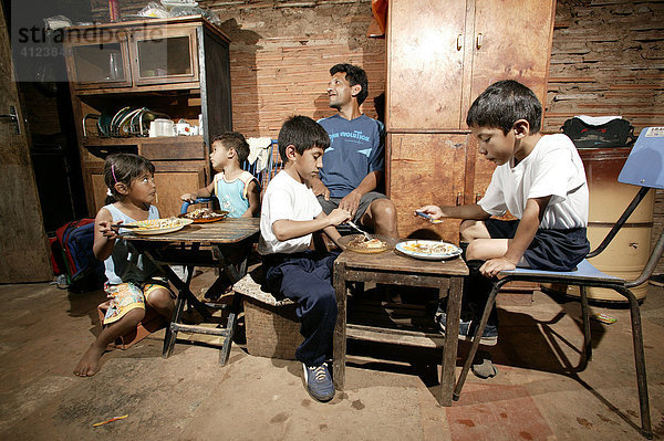 Guarani-Familie beim Essen  allein erziehender Vater     im Armenviertel Chacarita  Asuncion  Paraguay  Südamerika