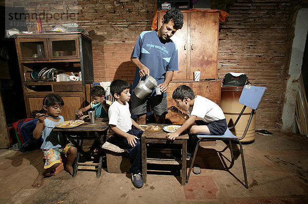Guarani-Familie beim Essen  allein erziehender Vater   im Armenviertel Chacarita  Asuncion  Paraguay  Südamerika