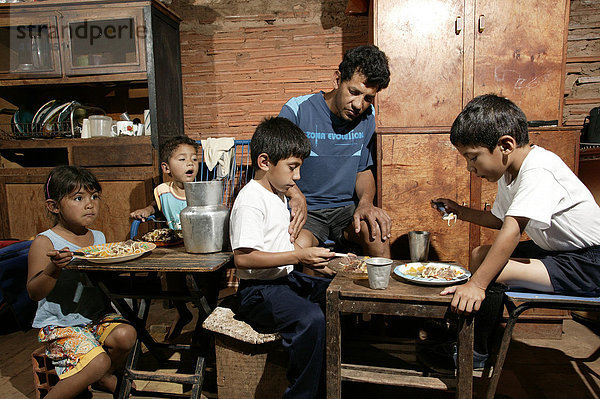 Guarani-Familie beim Essen  allein erziehender Vater   im Armenviertel Chacarita  Asuncion  Paraguay  Südamerika