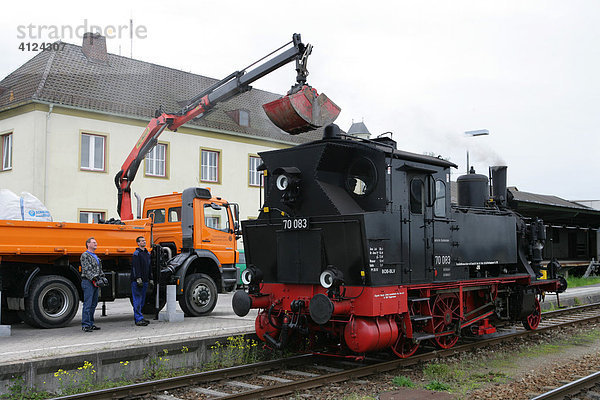 Historisch Dampflokomotive wird mit Kohle beladen